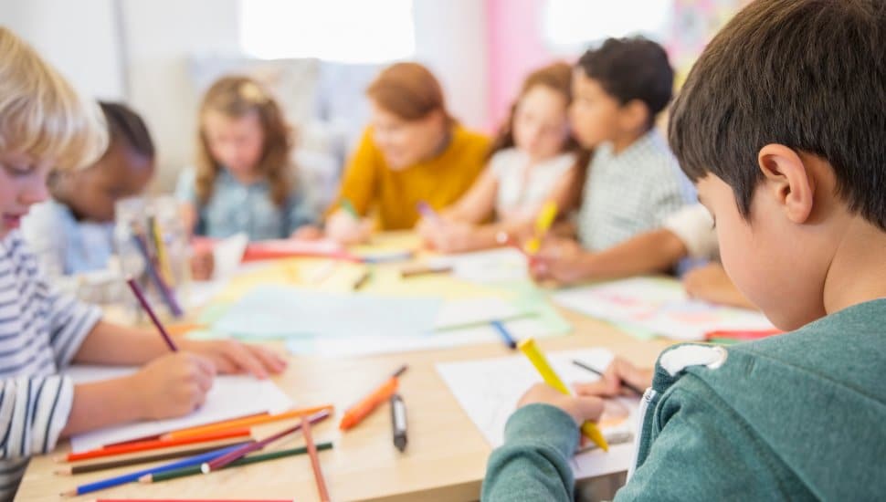 Group of kids drawing at a table.
