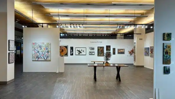 Wide view of the Lancaster Art Vault gallery showcasing colorful abstract paintings and modern sculptures under soft lighting.