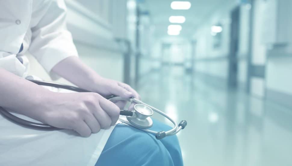 Doctor sits in empty hallway.