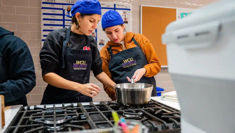 West Chester University nutrition students collaborate in the campus Food Lab, cooking and preparing meals as part of a community service project.