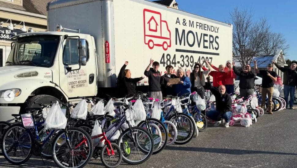 Dom Fixes Bikes team members with a moving van and a row of bikes.