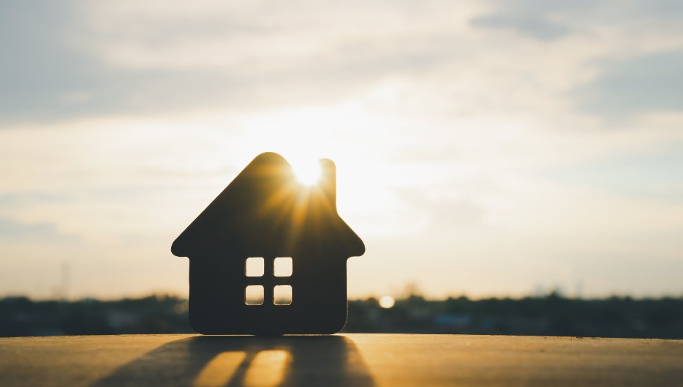 Wooden house model on wood background.