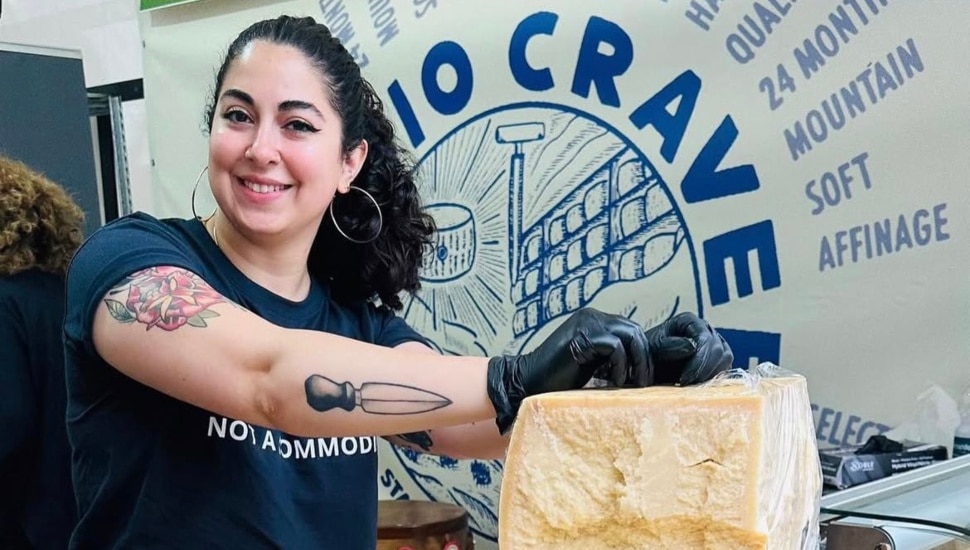Emilia D'Albero cuts a chunk of cheese.