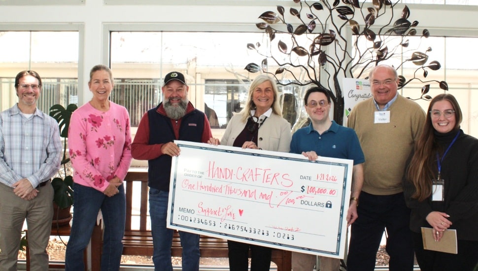 Nonprofit representatives receive giant donation check.