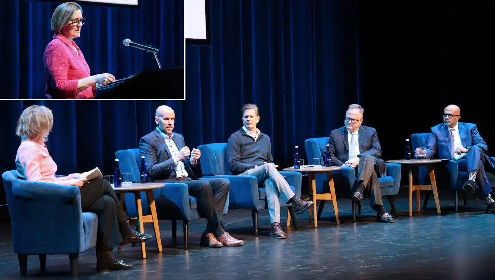 Woman delivers keynote speech with panel discussion.