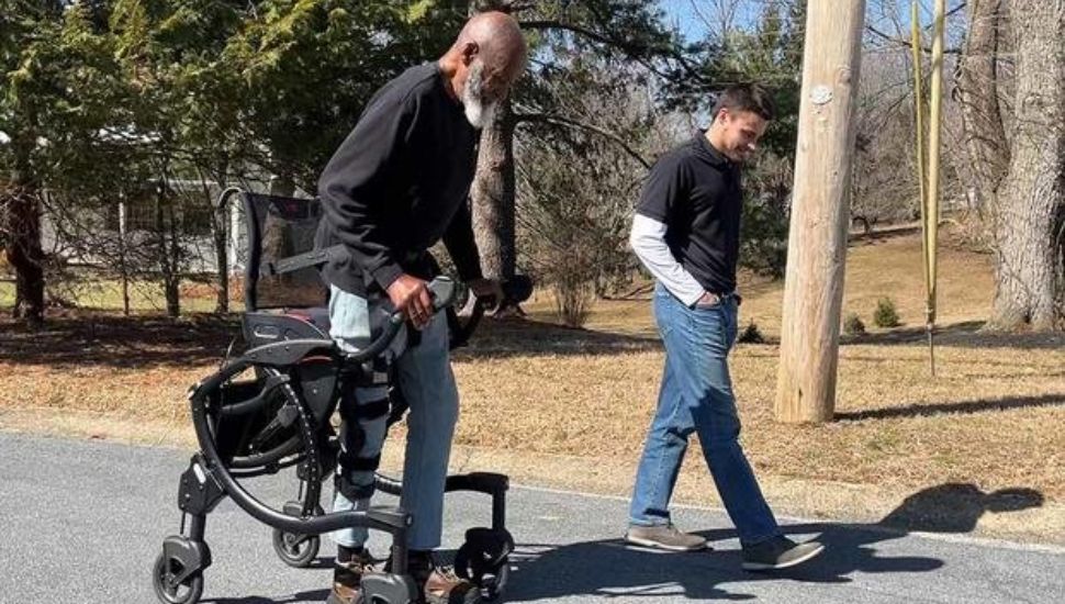 Two people walking outside and one person walks with a Zeen.