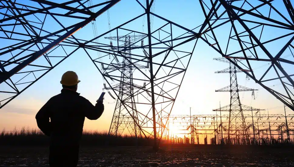 Electricity worker looking at electric pylons.