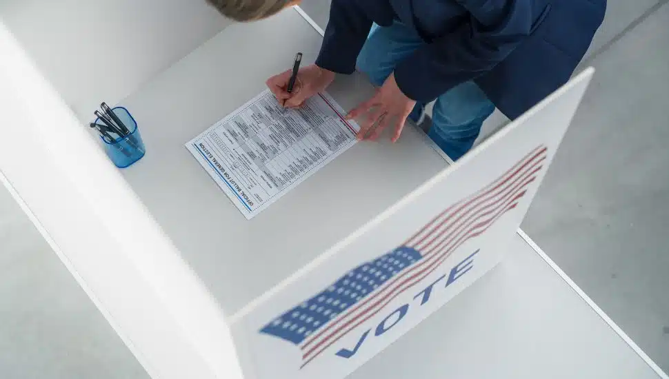 Person voting in person on a ballot.