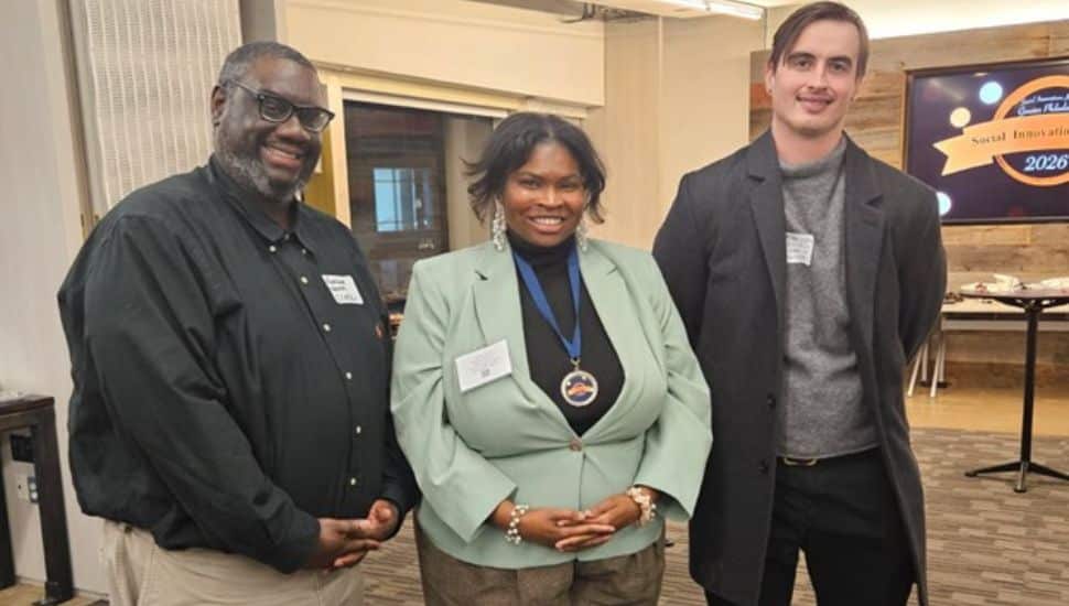 Javonna Wylie wearing a medal stands between two colleagues at the 2026 Greater Philadelphia Innovation Awards event.