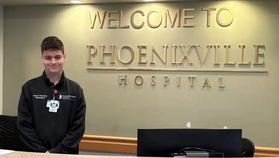 Phoenixville Hospital guest services attendant Jack Edwards at the hospital welcome desk.