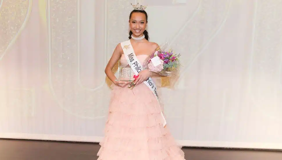 Ksenya Wong with award wearing light pink dress.