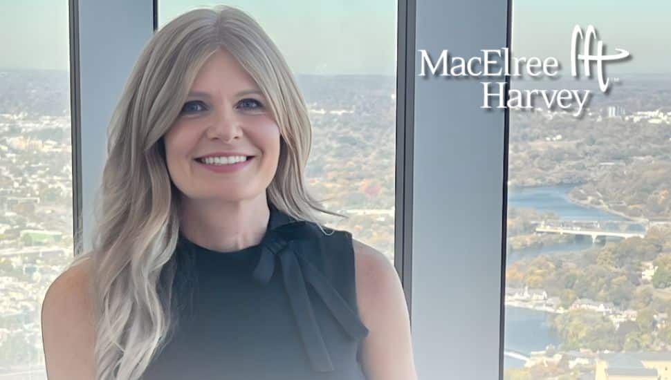 Michelle Foster of MacElree Harvey standing in front of a window with a scenic view, announcing her appointment to the Chester County Bar Foundation Board.