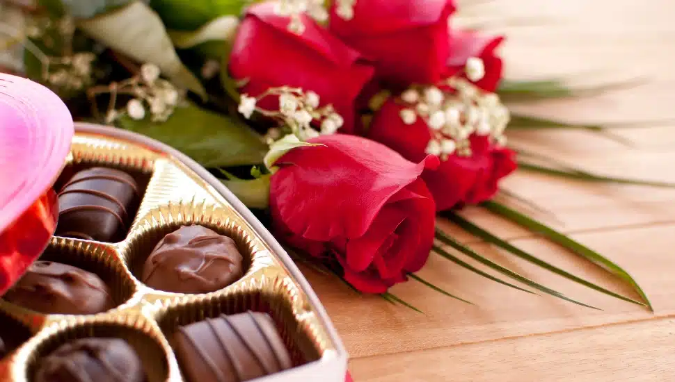 Valentine's Day roses and chocolate candy on a wooden table