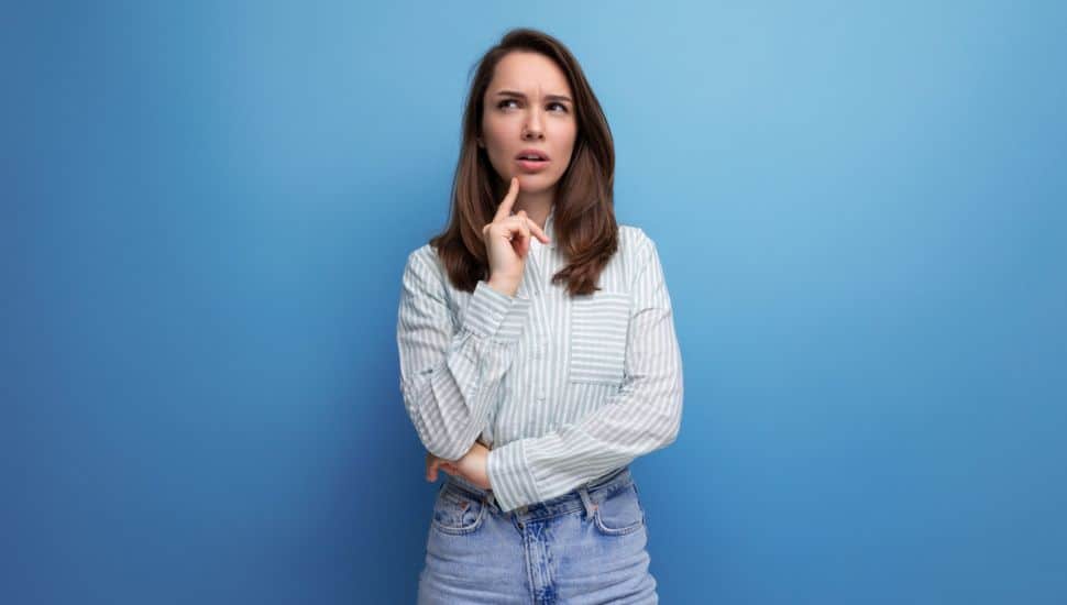 Woman thinking with blue background.