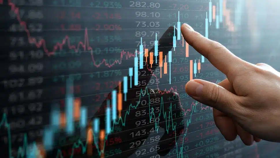 Stocks chart with a person's finger pointing on screen.