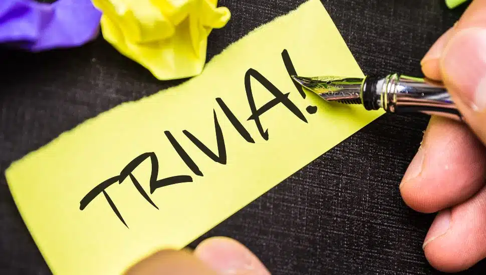 Person writing Trivia on piece of paper.