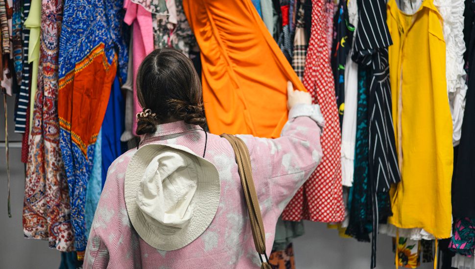 A shopper looking at clothing at a consignment shop.
