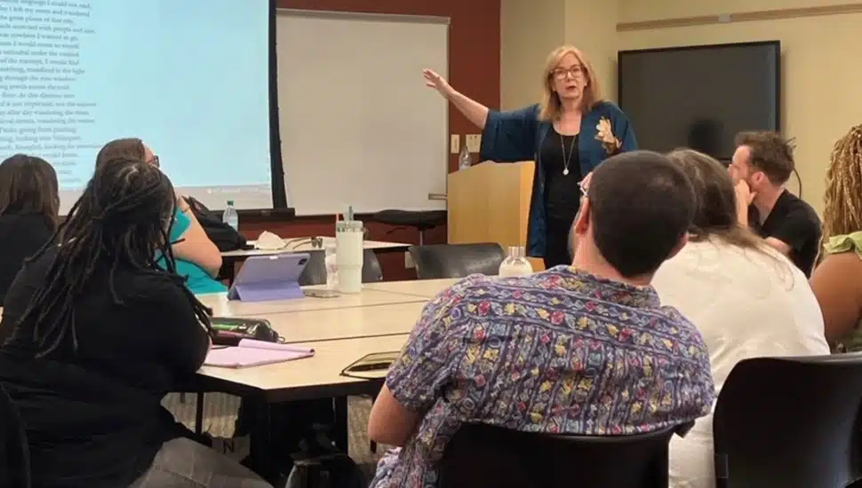 Poet teaches class to graduate students.