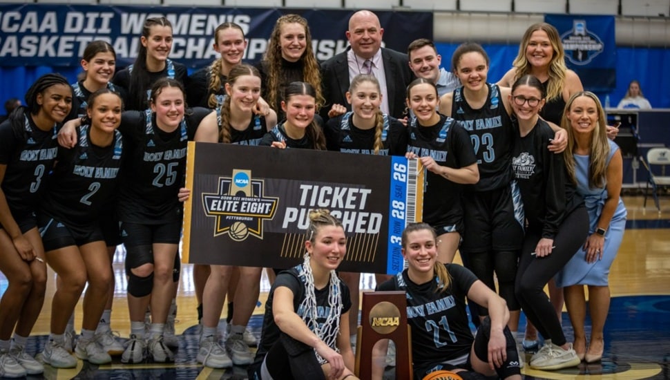 Women's college basketball team celebrates championship win.