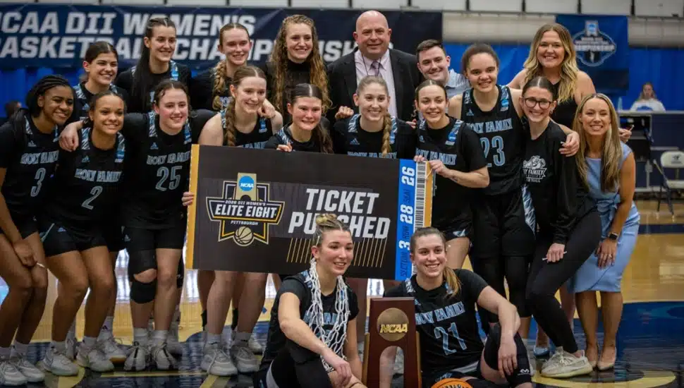 Women's college basketball team celebrates championship win.