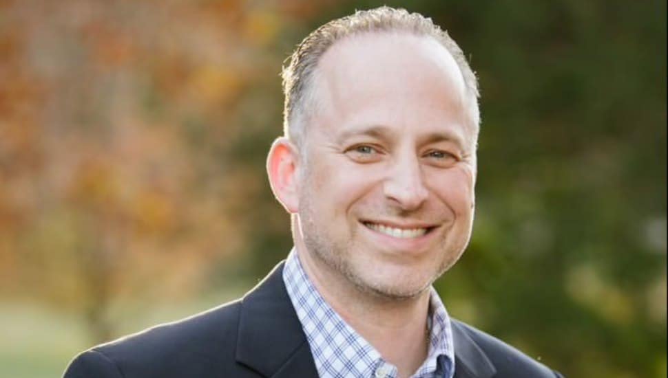 Jayson Rieger headshot with autumn background.
