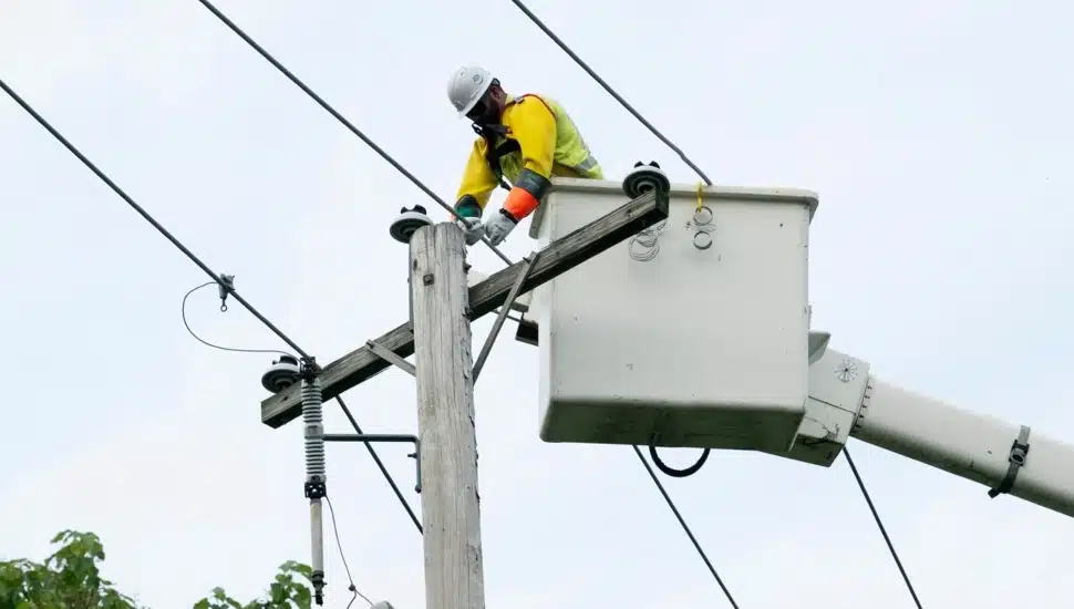 Utility worker fixes power line.