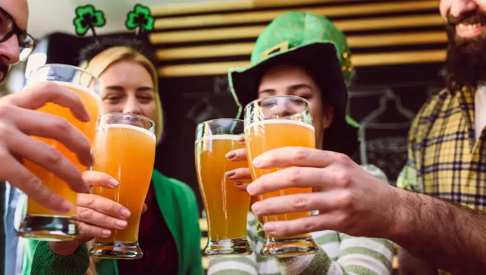 A group of friends toasting beers at a Saint Patrick's Day celebration.