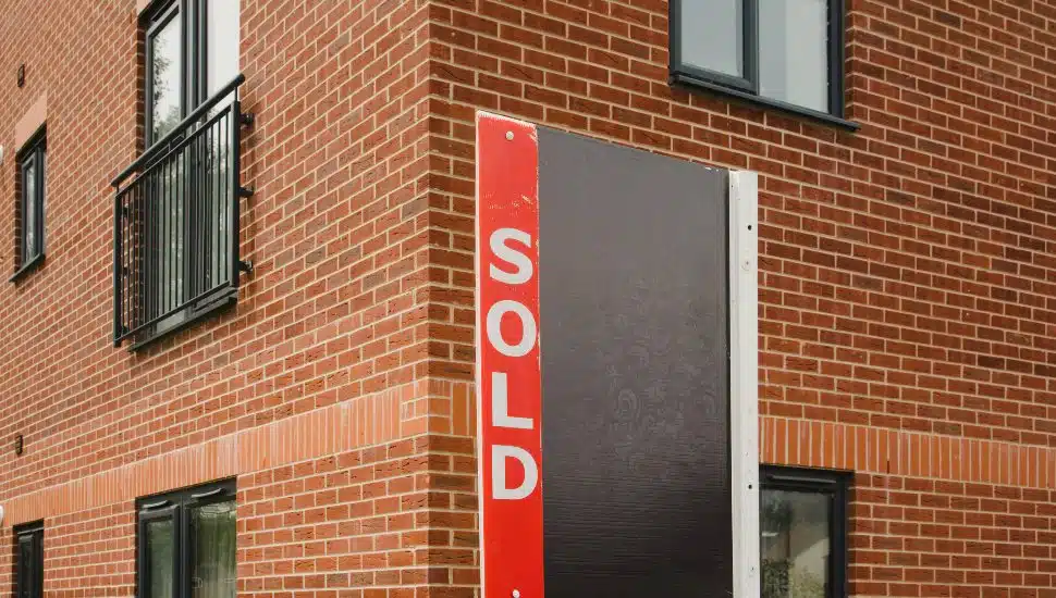 Sold sign on side of brick building.