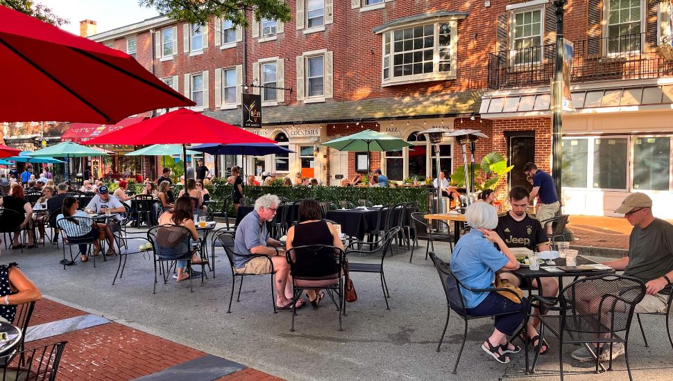 Outdoor dining with people eating at tables on Gay Street in West Chester.