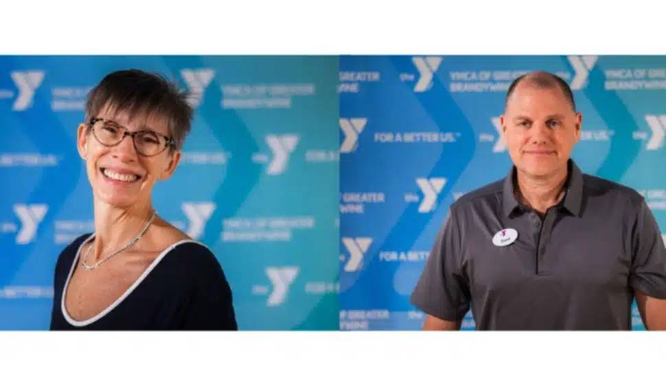 Valeria Tenreiro and Dave McNamara, newly appointed leaders at the YMCA of Greater Brandywine, pictured in front of YMCA branded backdrop in West Chester, PA.