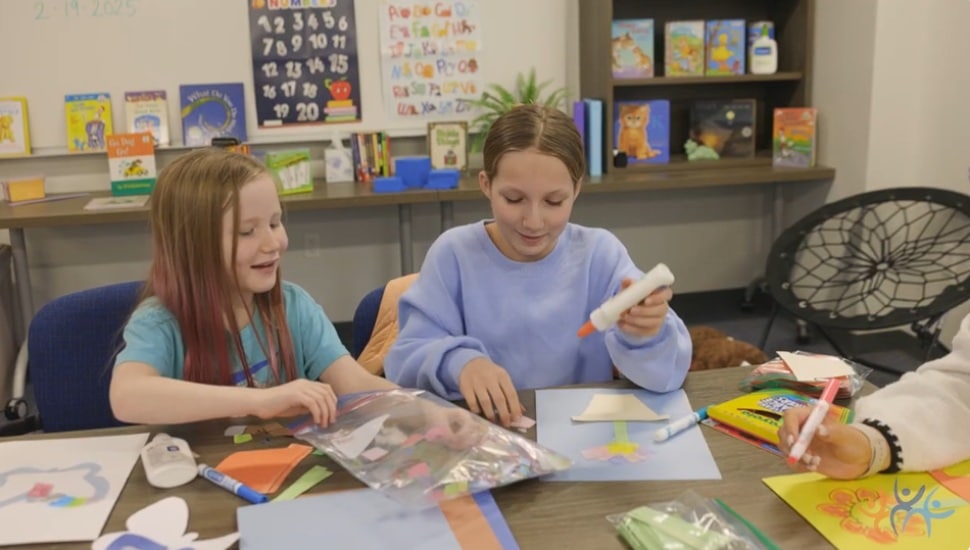 A CCRES staffer works with a young girl on a project.