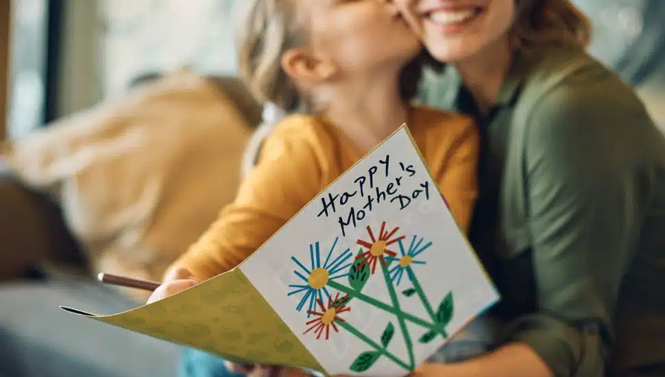 Close-up of woman receiving greeting card from her daughter on Mother's Day.