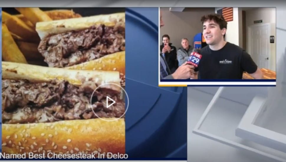 Bob Kelly of Fox 29 talks to Niko, owner of Niko's Steaks, with the award-winning cheesesteaks on display.