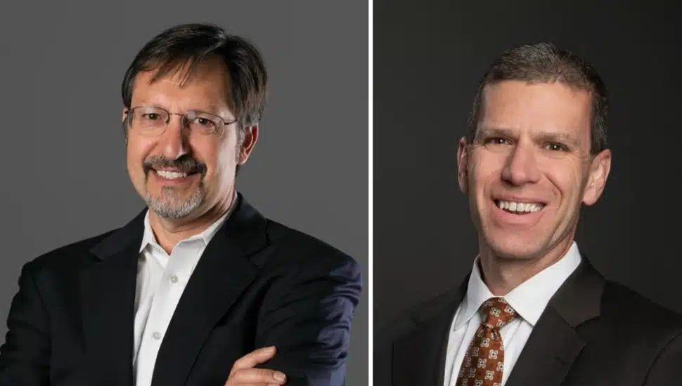 Headshots of two male middle-aged business executives in dark suits.