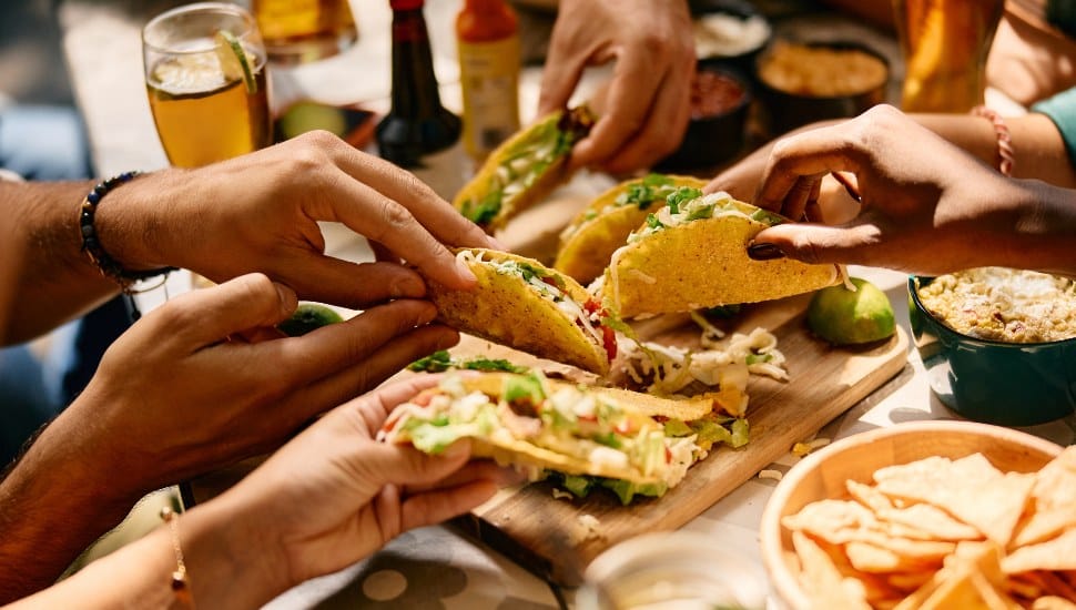Close up of people eating Mexican food in a restaurant.