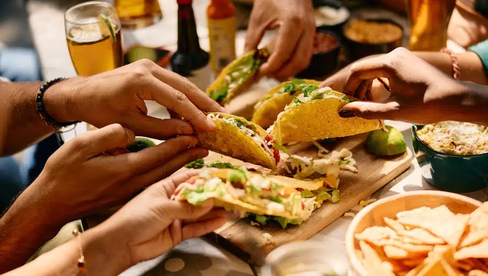 Close up of people eating Mexican food in a restaurant.