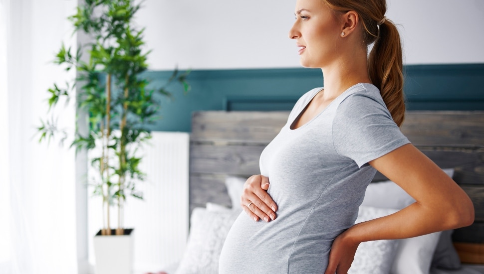 Young pregnant woman suffering from backache.