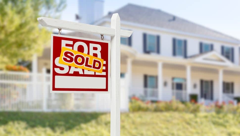 Sold Home For Sale Real Estate Sign in Front of house in yard.