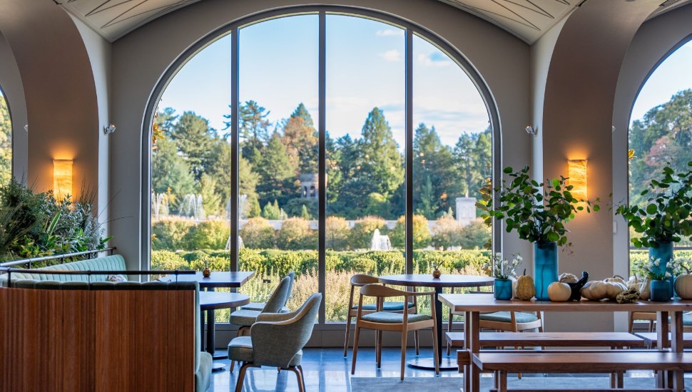 The dining room at 1906 frames the Main Fountain Garden through soaring arched windows.