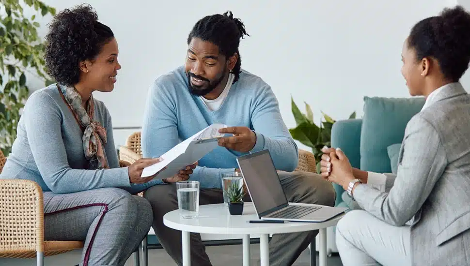 Young couple sits down with their financial advisor to discuss loan options.
