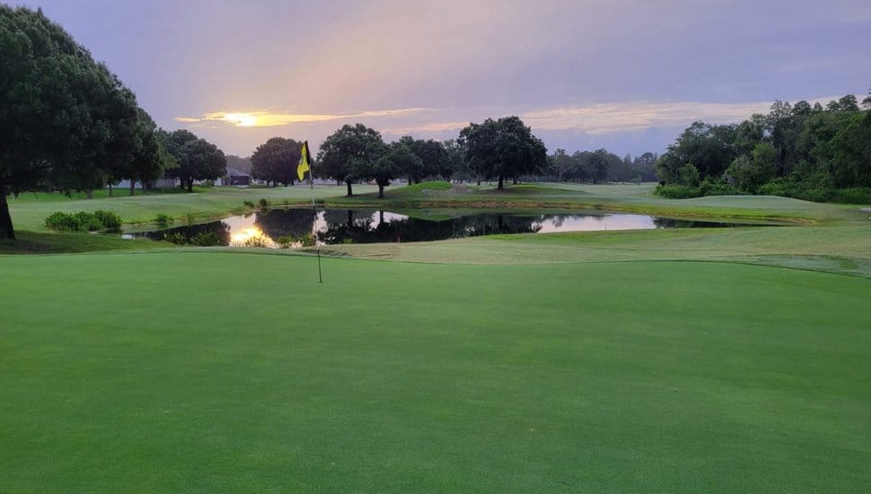 A green at South Florida's Cypress Creek Golf Course overlooking some water.