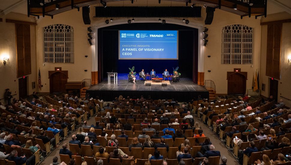 Large crowd in auditorium for last year's Executive Insights event with CEOs on stage.
