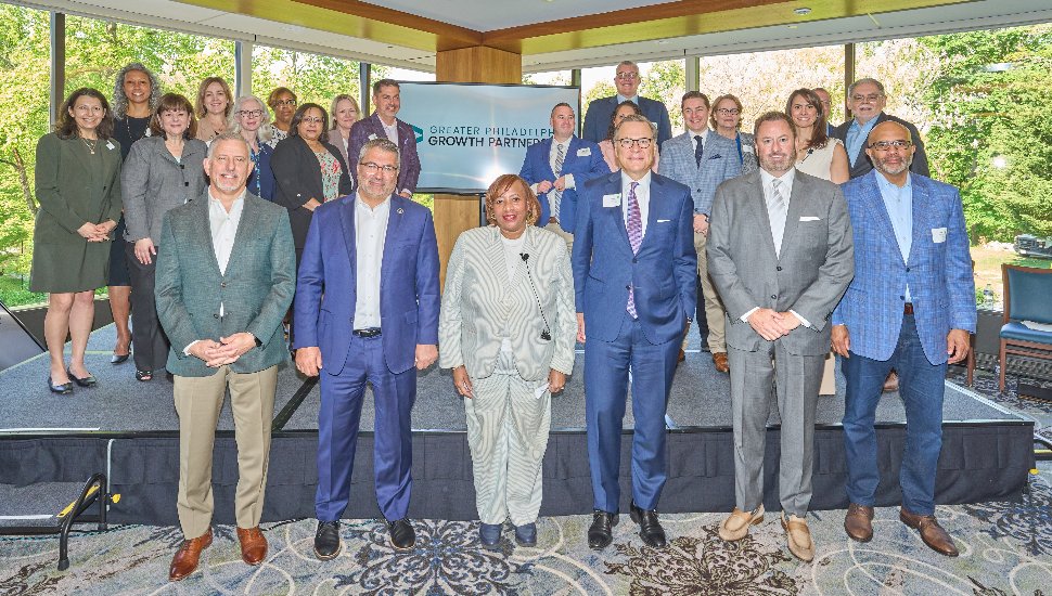 Group photo of CCEDC and Workforce Development members on a stage wearing professional attire.