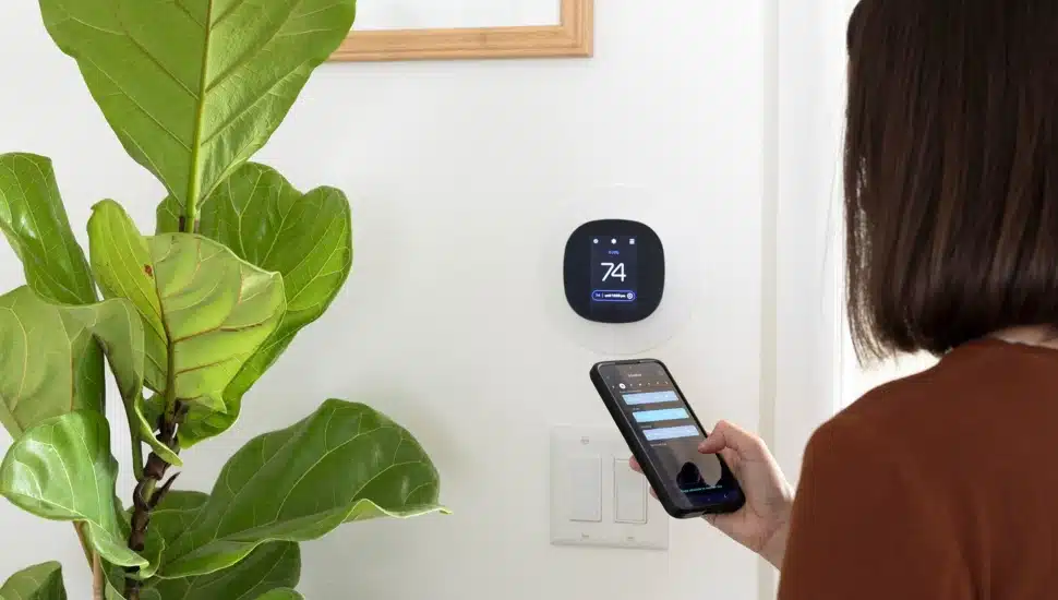 Woman programs a smart thermostat.