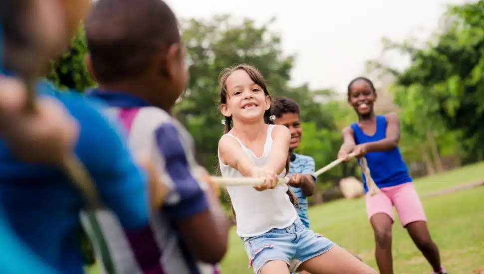 Kids playing tug of war outside.