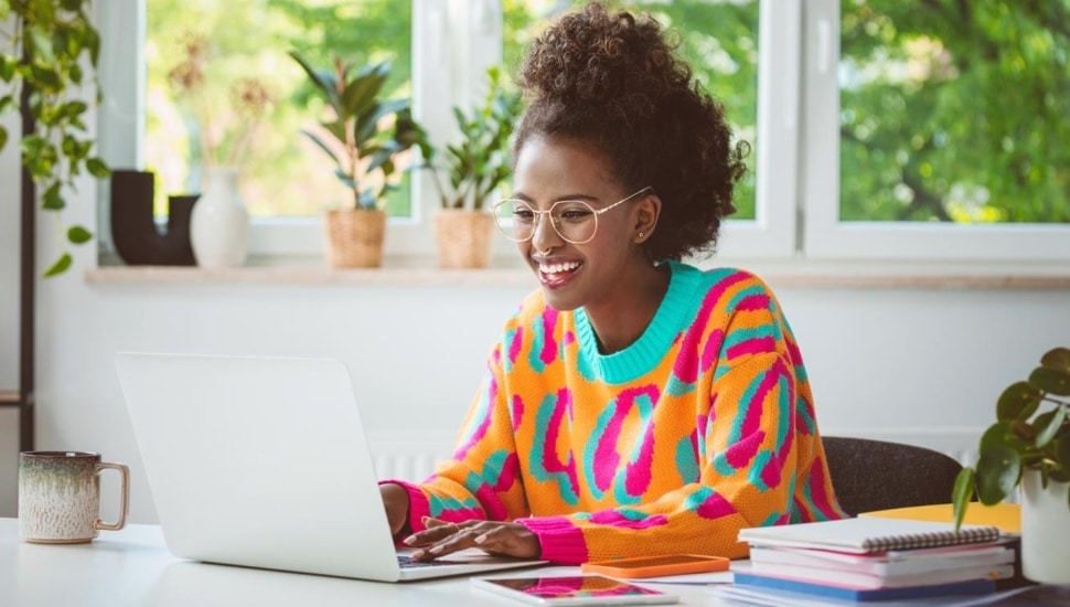 Young woman works on laptop computer.