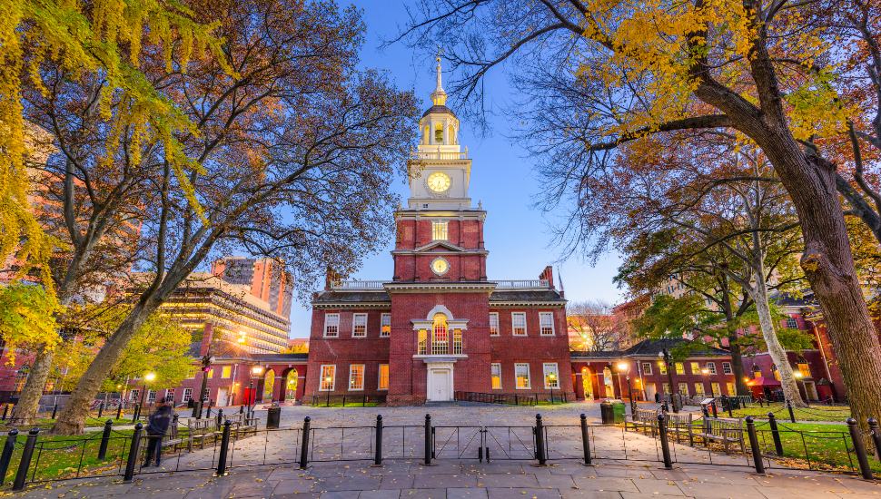 Independence Hall exterior in Philadelphia framed by autumn trees at dusk