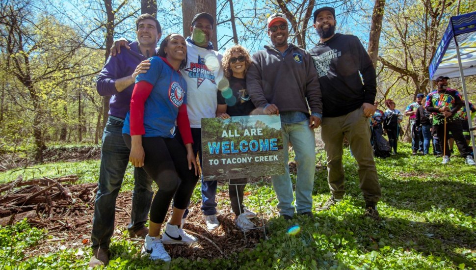 Environmental advocates pose for picture in green space.