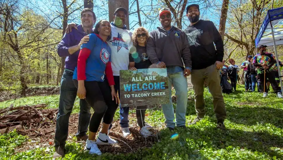 Environmental advocates pose for picture in green space.